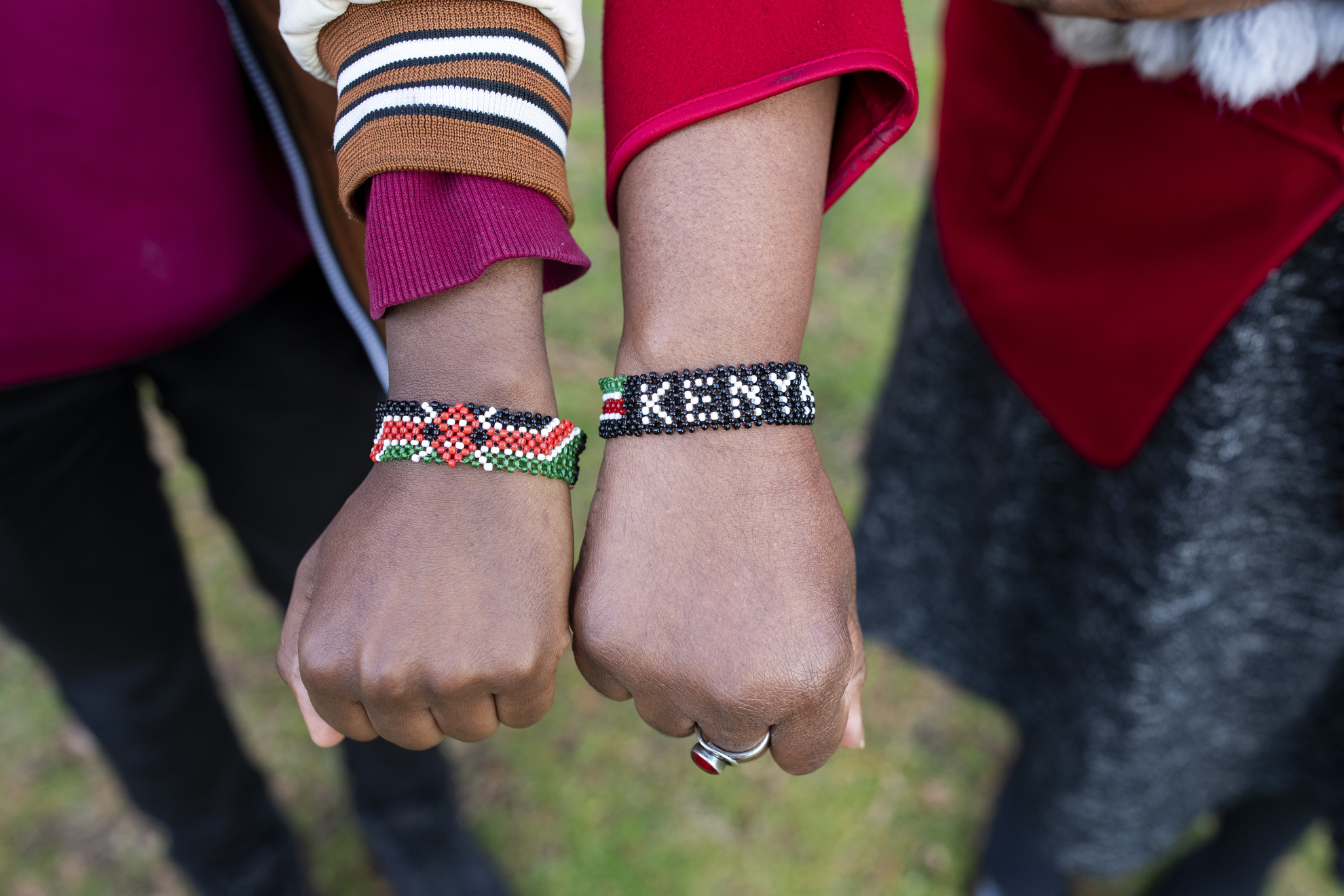 Emmanuel Enan Gachogu Muriuki (left), a freshman, and Sheila Thimba, the Dean of Administration and Finance, show off their Kenya bracelets in Harvard Yard. The two are both from Kenya.