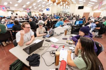 Learners gathered at tables with laptops during a gaming contest.