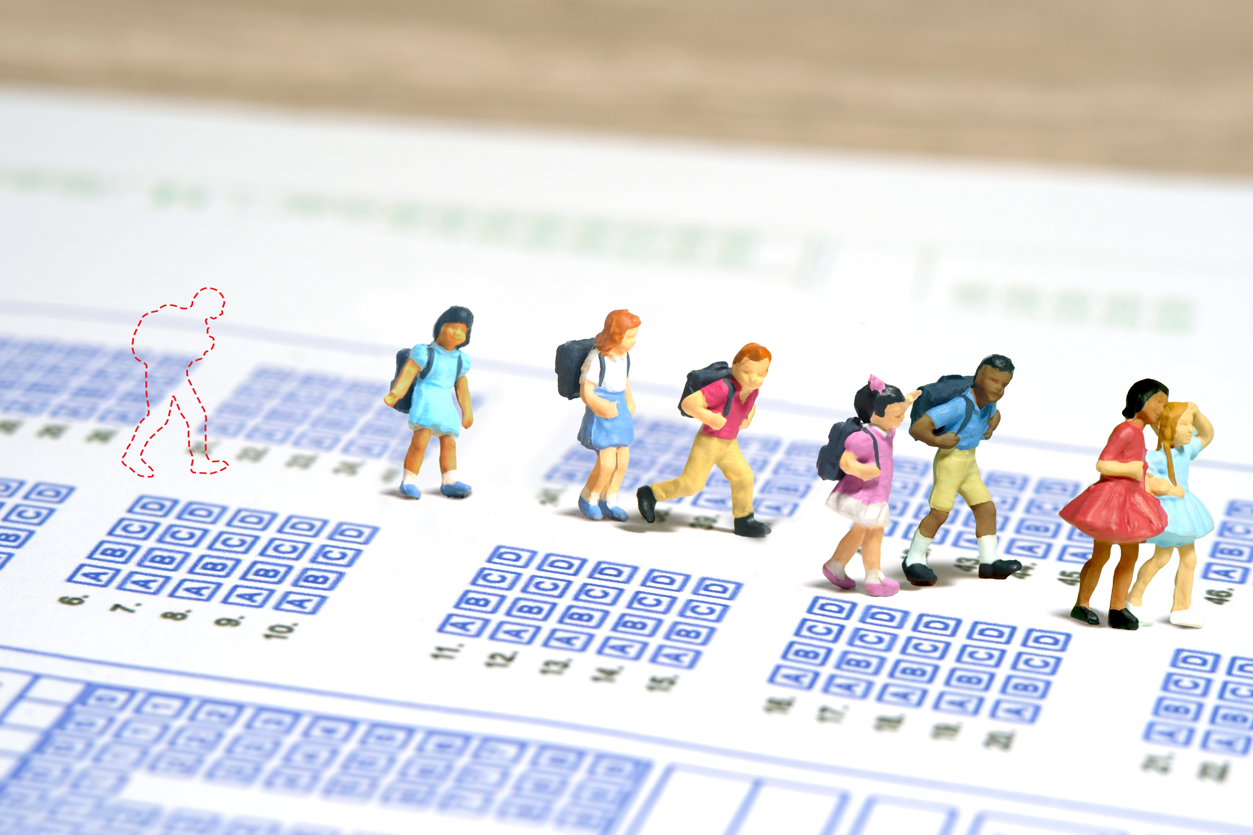 Illustration of a child left behind a group of schoolchildren on mathematics and reading examinations.