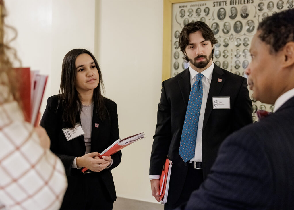 WashU students Megan Manaj (left), Nicole Lukens (center) and Luke Johnston engage with Missouri state Rep. Del Taylor. (Photo: Whitney Curtis/WashU)