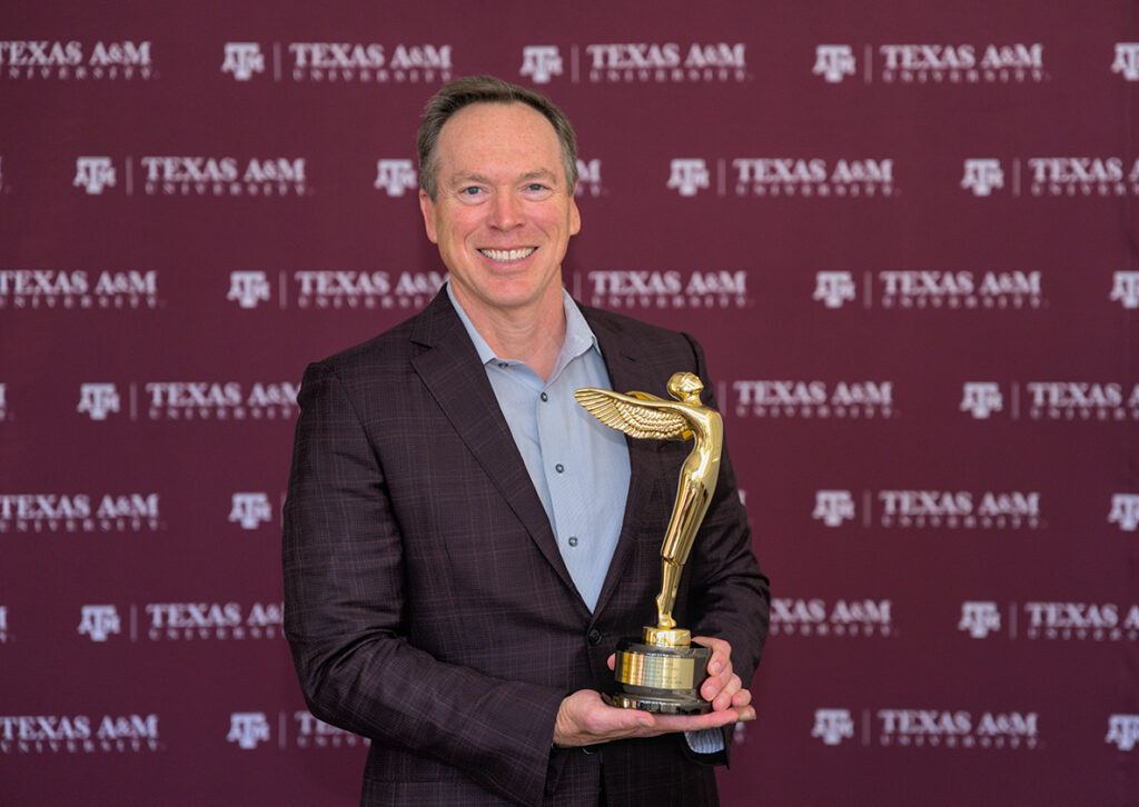 An image depicting a man holding a trophy.