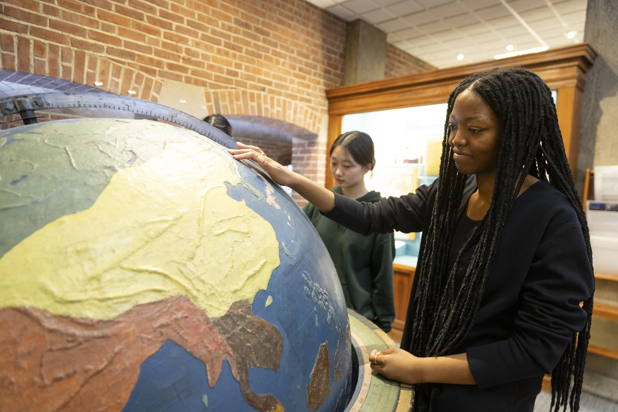 Amy Ojeaburu '25 studies a large tactile globe.