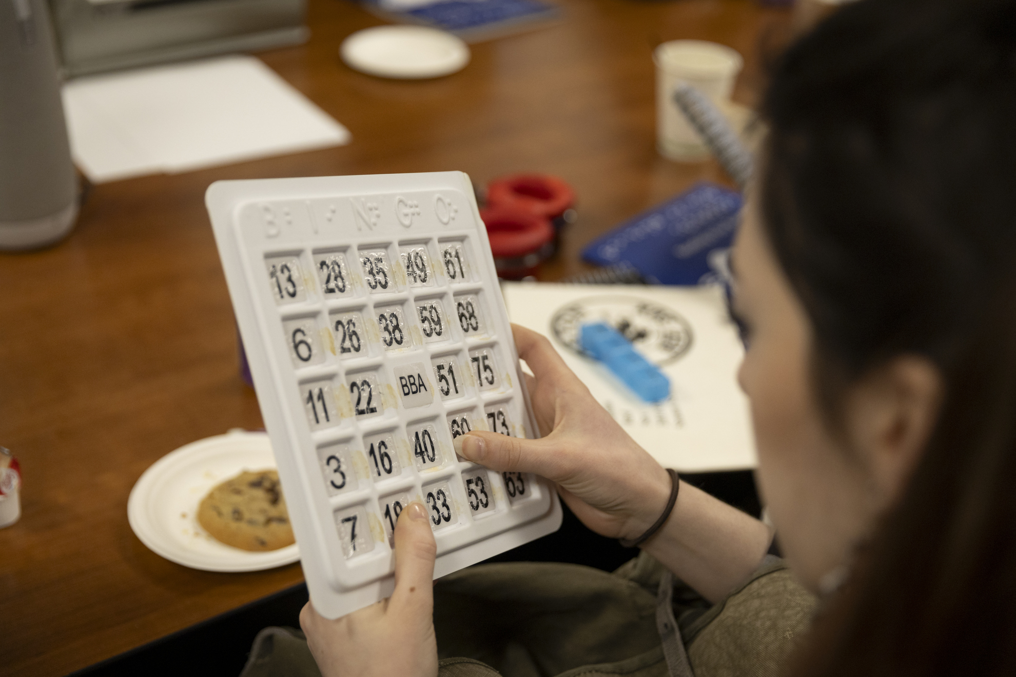 A student looks at a braille bingo card.