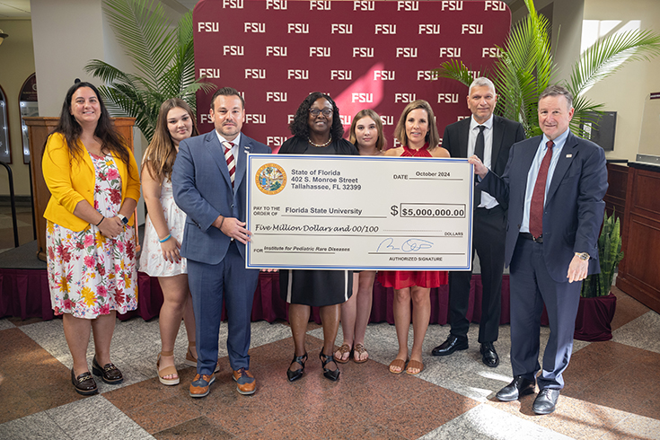 Rep. Adam Anderson, R-Palm Harbor, bestowed FSU President Richard McCullough with a $5 million check from the State of Florida to assist the FSU Institute for Pediatric Rare Diseases during the 2024 Pediatric Rare Disease Symposium. (Bill Lax/FSU Photography Services)