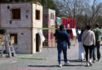 Symposium participants walk past a row of two-story wood structures built for the ASCE Timber-Strong Design Build Competition. (Photo by Lillian Ballance)