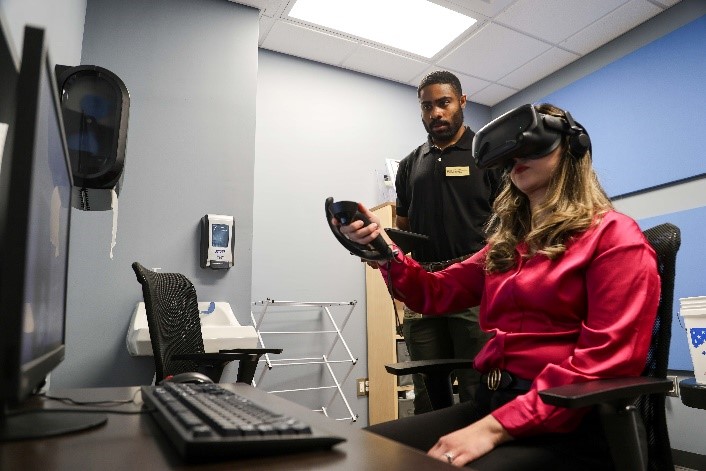 Elliot Bodre, a College of Medicine Bridge student, and Grecia Caswell, a research assistant, both affiliated with the Kozel and Johnson Neuromodulation Lab at FSU, assess the virtual reality equipment designated for use by participants in the clinical trial.