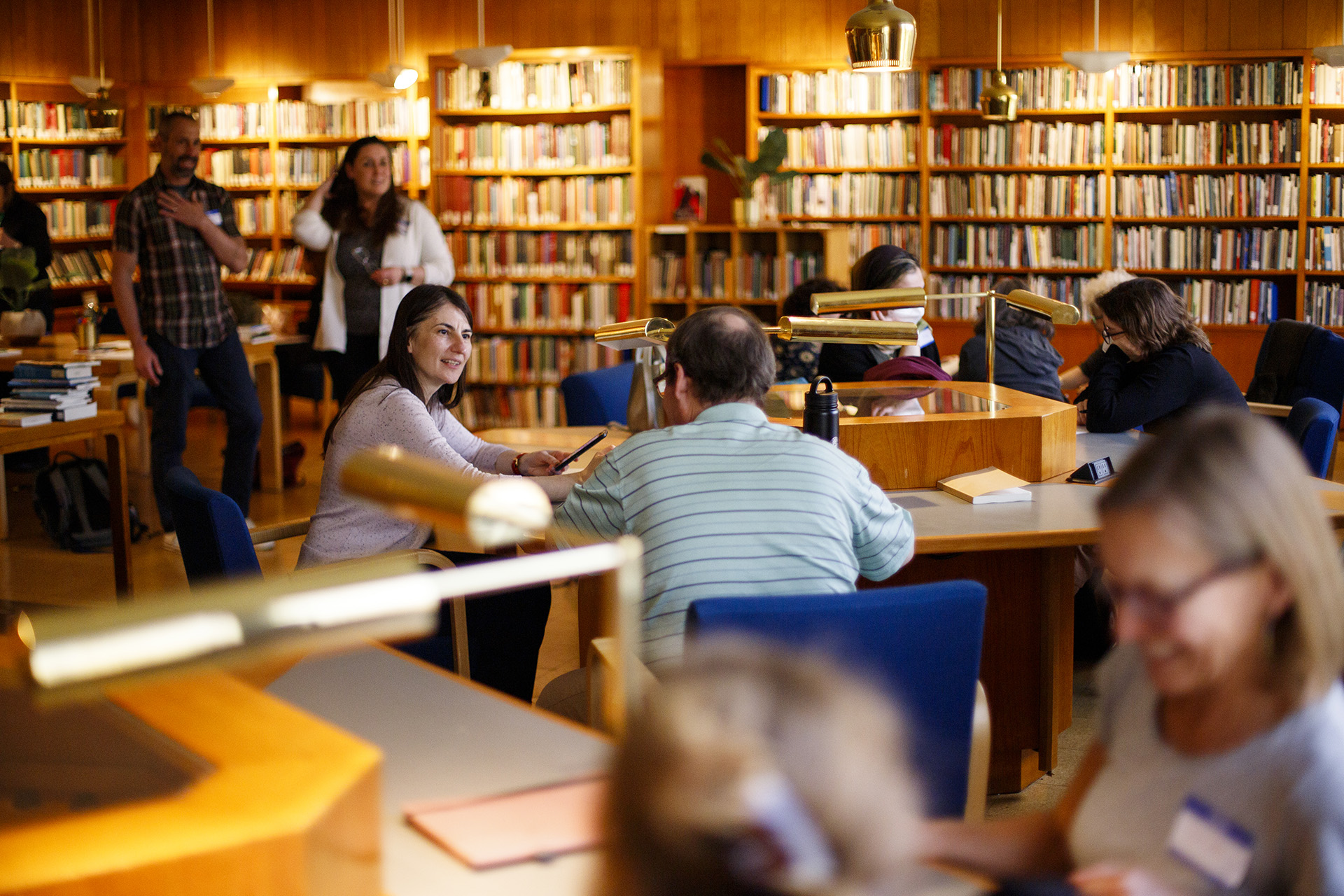 Writers browsing bookshelves and gathering around tables in the Woodberry Poetry Room.