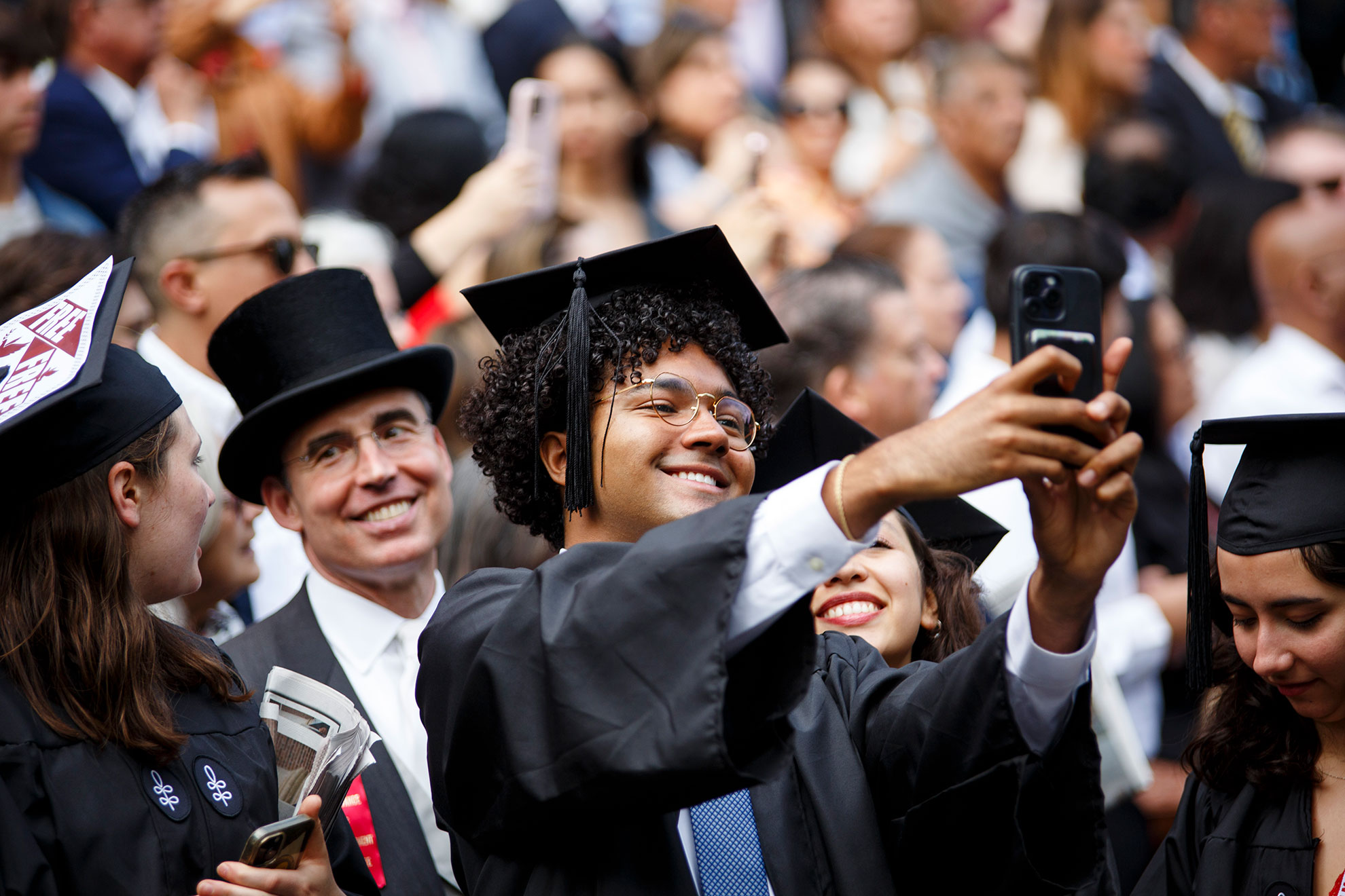 Graduates take photos in front of Widener Library.