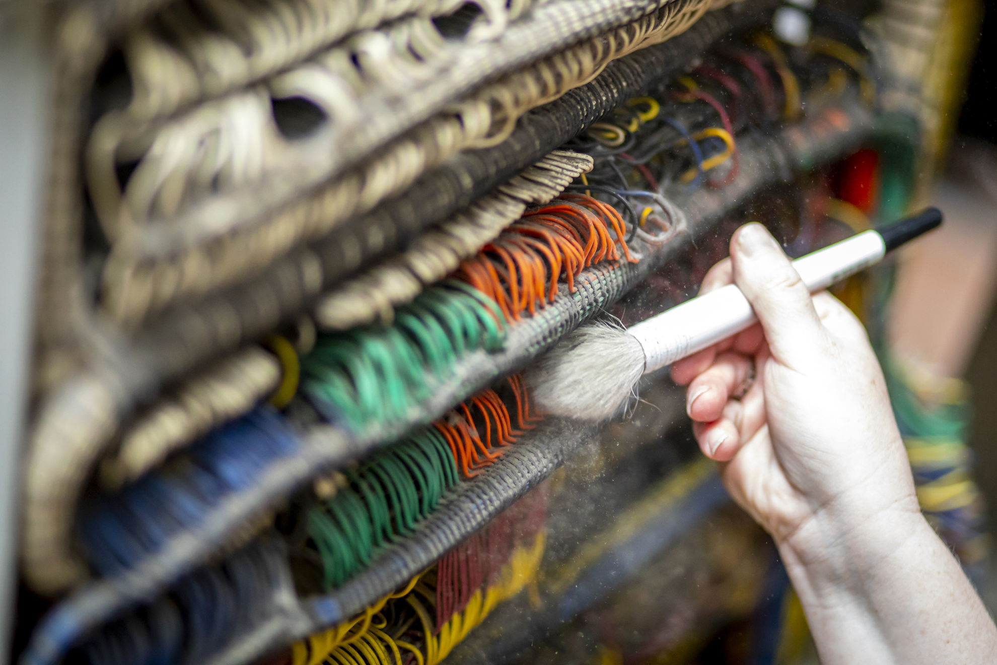 Sara Frankel, the Collections Manager for the Collection of Historical Scientific Instruments, cleans years of dust from the interior parts of the computer.