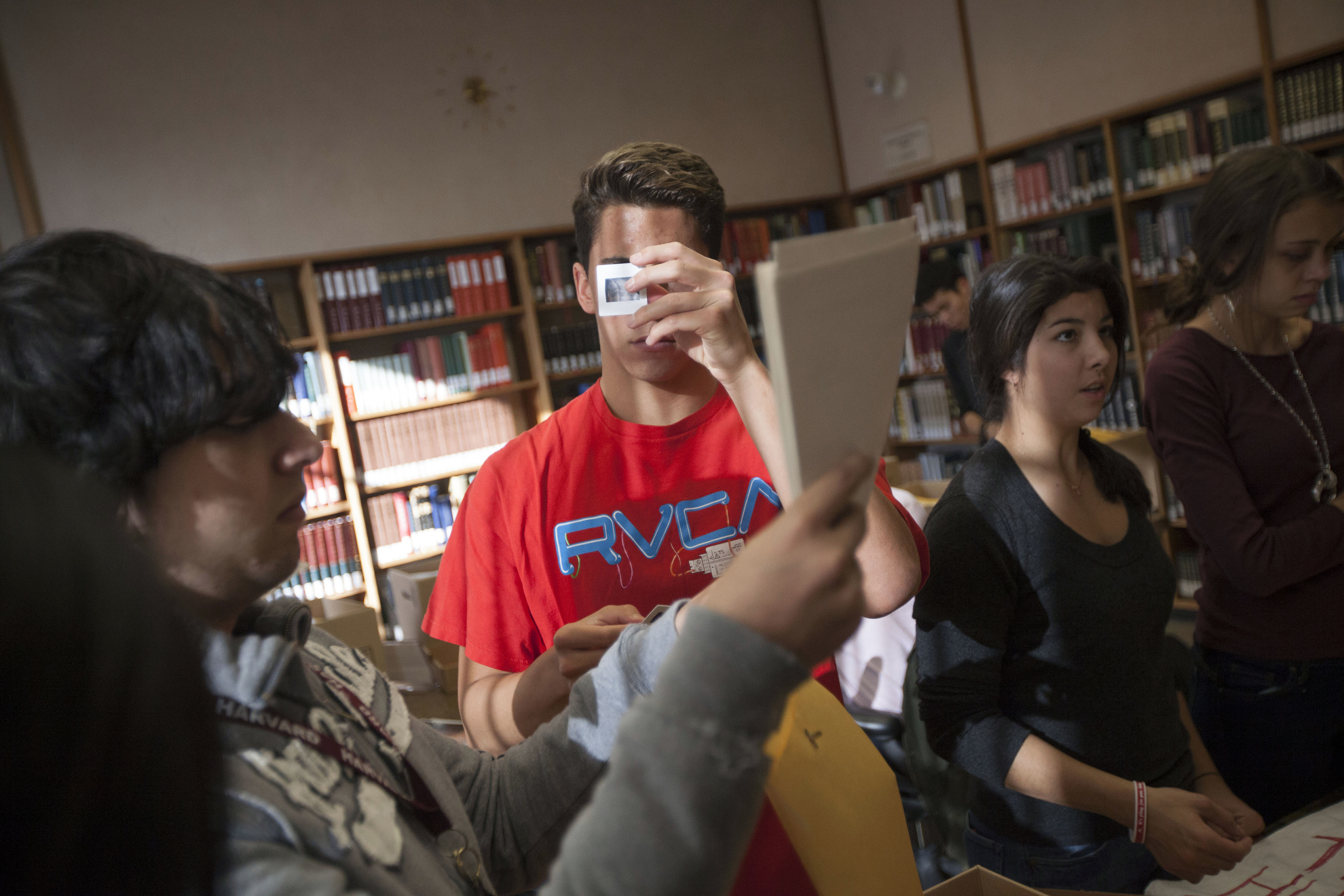 Charles Orta (from left), Blake Lee, Miye D'Oench, and Sarah Fellay examine research materials inside the Harvard-Yenching Library.