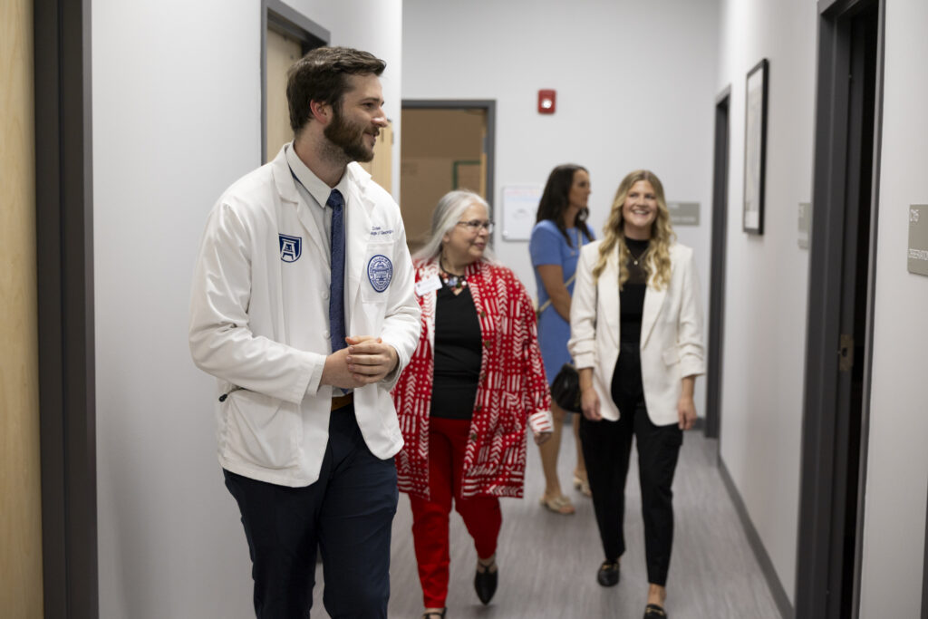 From left to right, first-year Medical Partnership student John Dusk gives a tour of the clinic to College of Family and Consumer Sciences Dean Anisa Zvonkovic, Clarke County School District Executive Director of Student and Family Services Tessa Barbazon and Family and Consumer Sciences faculty member Megan Ford after the ribbon cutting ceremony at the Clarke Middle Health Center at Clarke Middle School. (Andrew Davis Tucker/UGA)