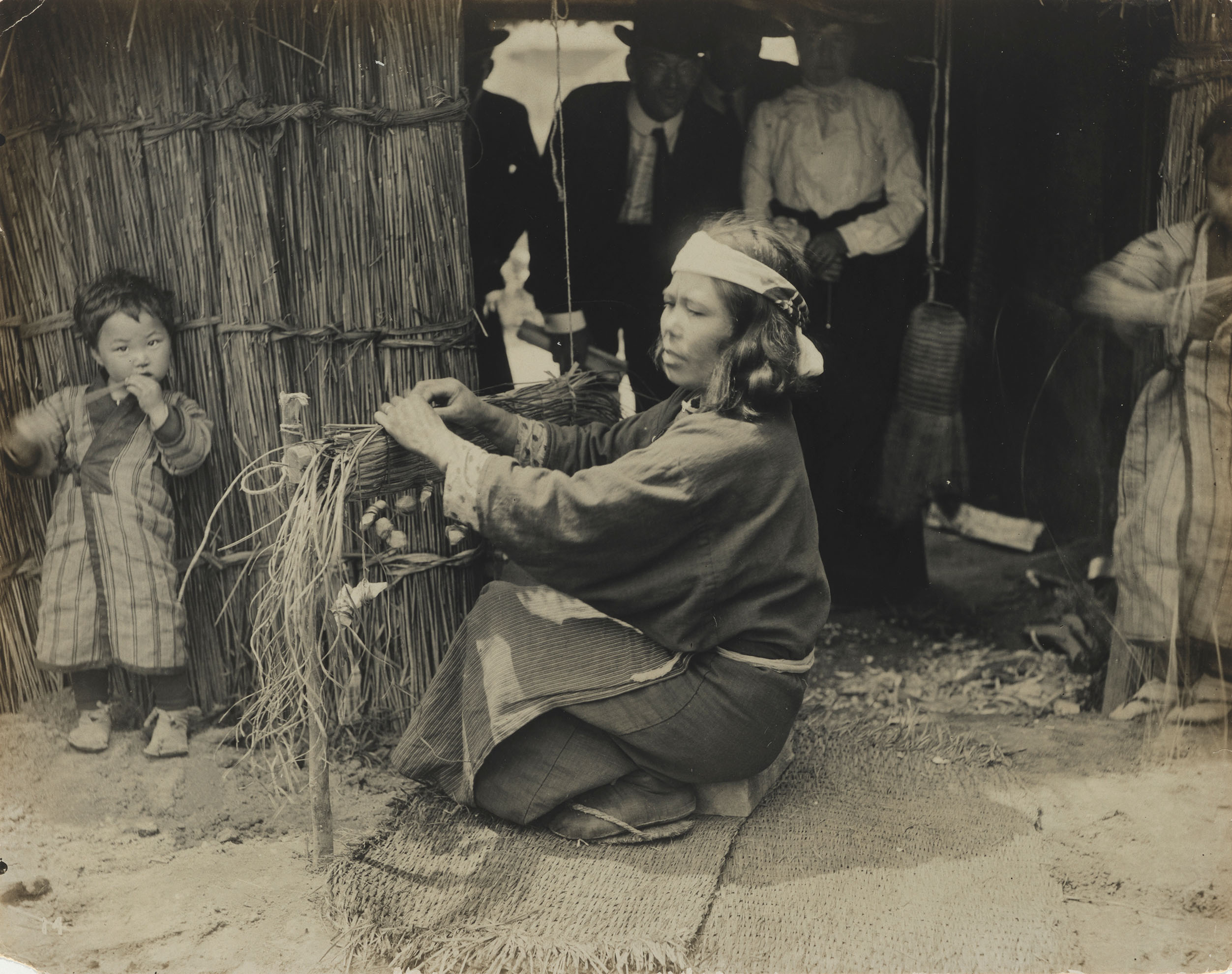 A monochrome photograph of a woman and children in a 'living exhibit' at the 1904 St. Louis World's Fair