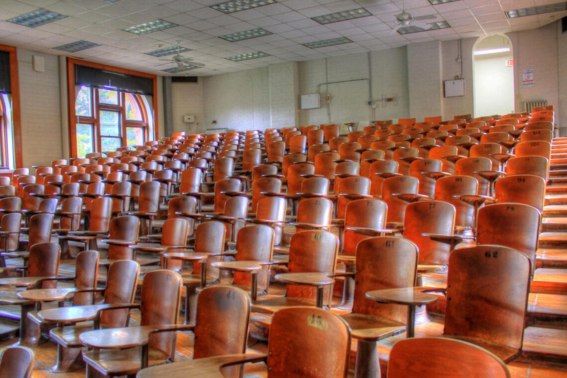 Rows of wooden seats in an unoccupied lecture hall