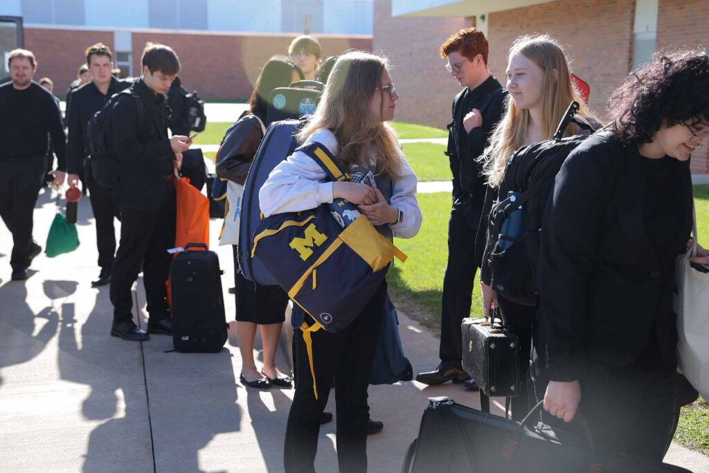 Students from the University of Michigan and members of the Symphony Band arrive at H. H. Dow High School for workshops and a concert.