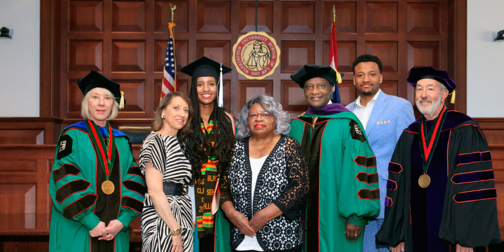 The Washington Family gathered in the Bryan Cave Moot Courtroom for a celebratory portrait following the ceremony. (From left:) Stefanie Lindquist, the Nickerson Dean and professor of law; Leslie Demourelle, Washington’s wife; McKenzie Washington; Ada Washington; Judge Washington; his son Washington; and Michael M. Greenfield, the George Alexander Madill Professor of Contracts & Commercial Law Emeritus.
