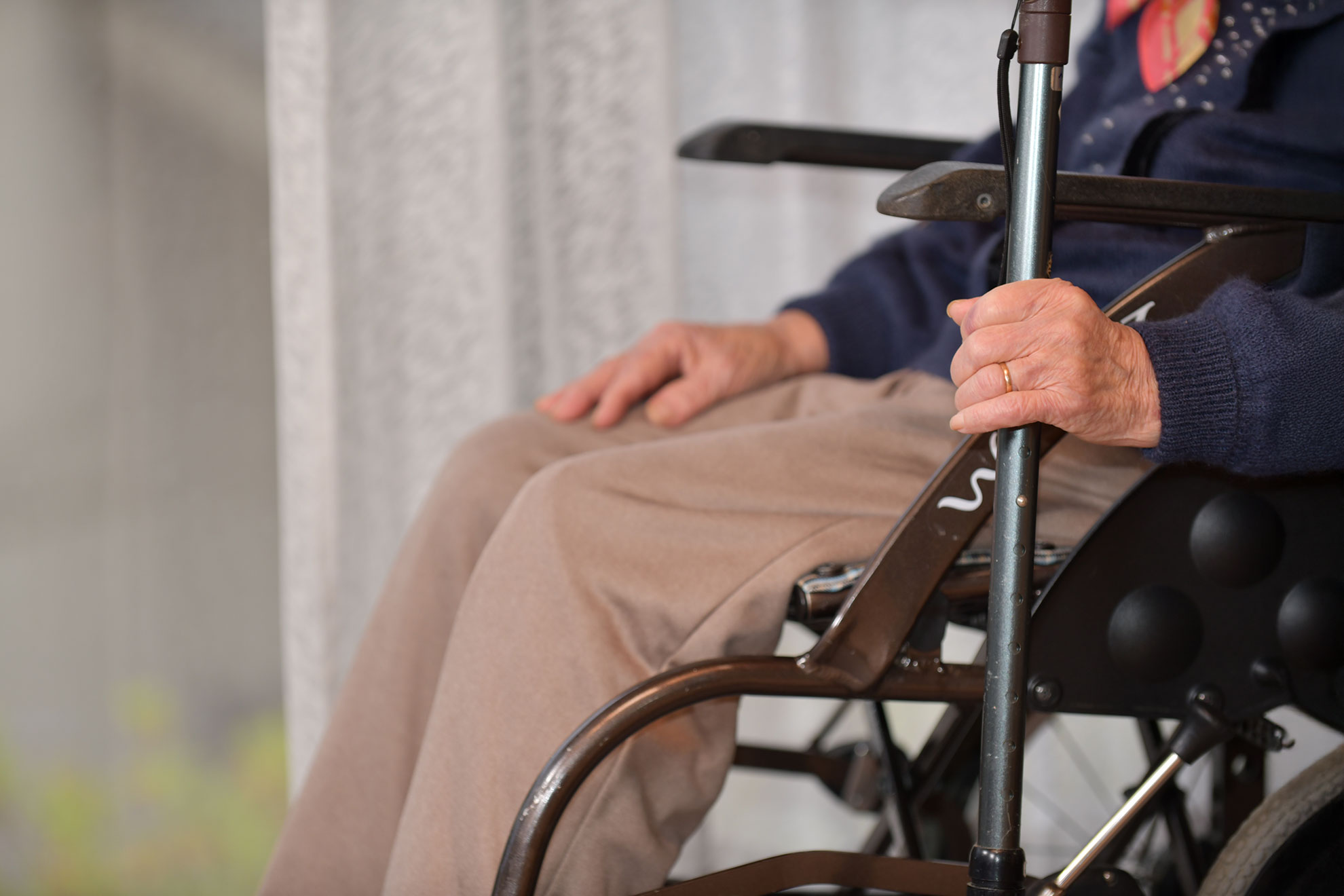 Elderly woman seated in a wheelchair.