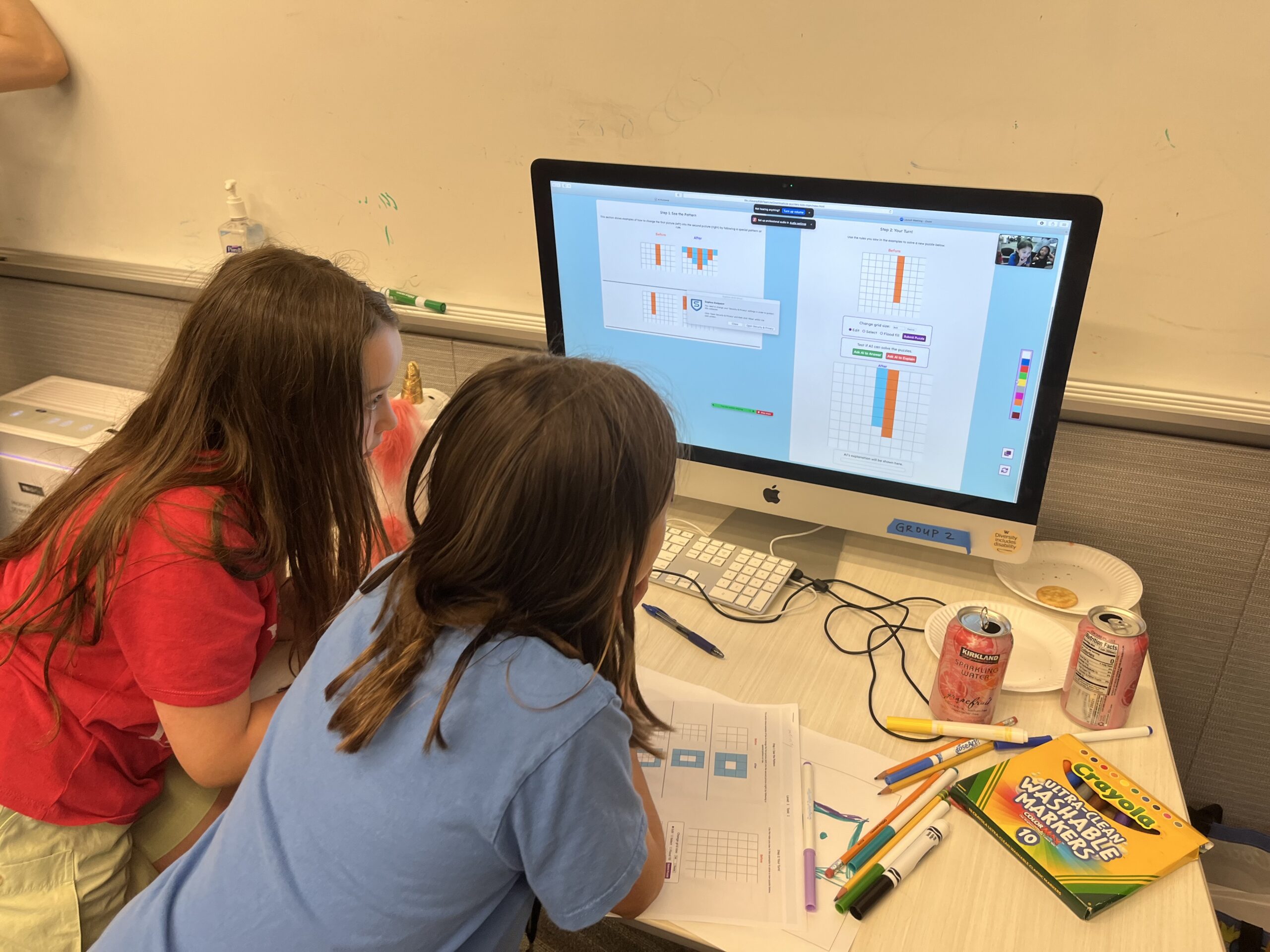 Two children engage in a game on a computer.