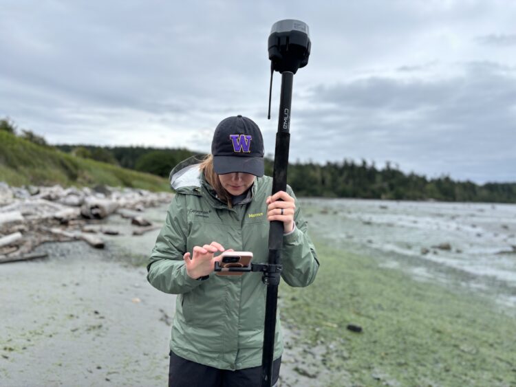 researcher operates field instrument on a beach