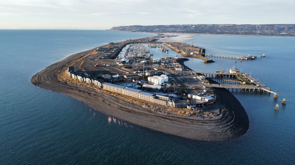 An aerial image captured from above the Homer Spit, a 4.5 mile stretch that projects into the water. On the left, fiber optic cables are submerged.