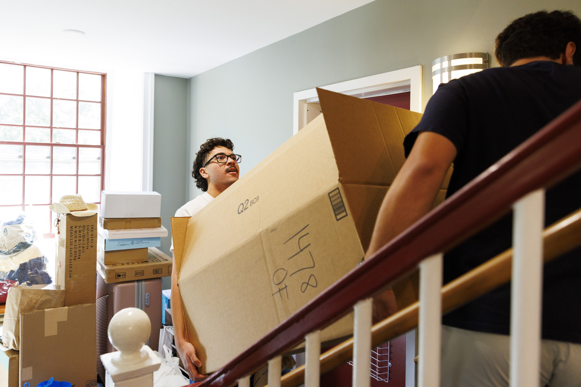 First-year Jose Garcia carries a box up the stairs at Hollis Hall.