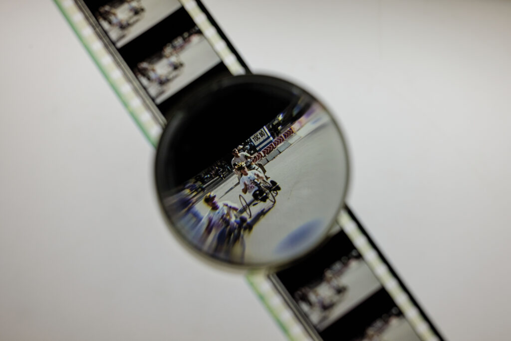 <i>Vietnam, Long Time Coming</i>, a 1998 Kartemquin Films documentary, follows a group of American and Vietnamese veterans on a 16-day, 1,200-mile bicycle journey along the coast of Vietnam. A film-editing loupe is used to examine a film reel. (Photo: Whitney Curtis/WashU)” class=”wp-image-710057″ sizes=”(max-width: 1024px) 100vw, 1024px”><figcaption class=