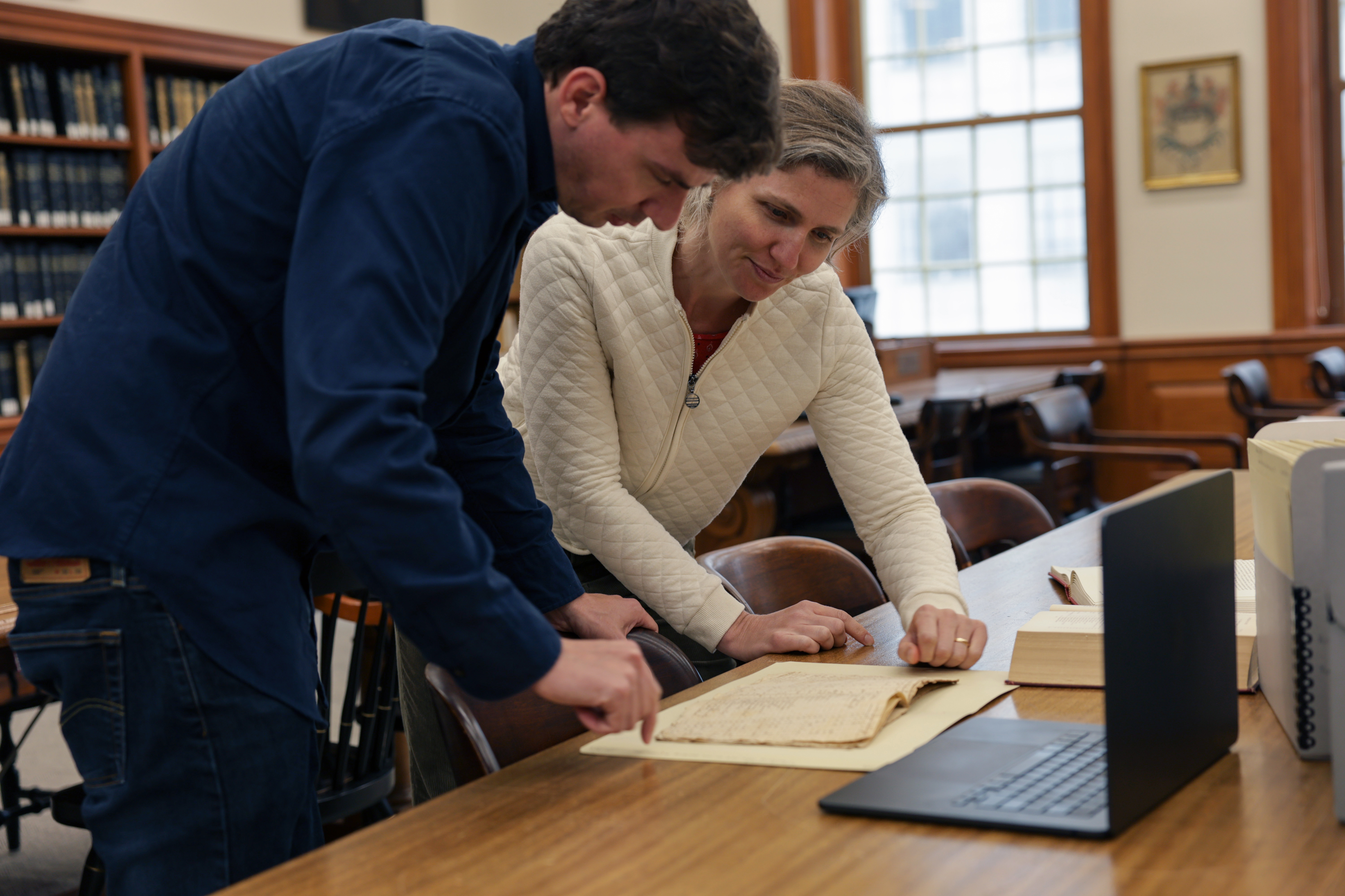 Gabriel Raeburn reviewing documents with fellow researcher Christine Bachman-Sanders.
