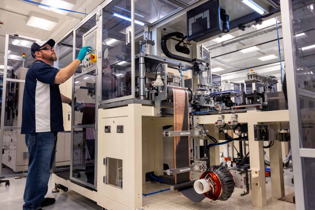 Man operating an electrode punching device in a contemporary lab.