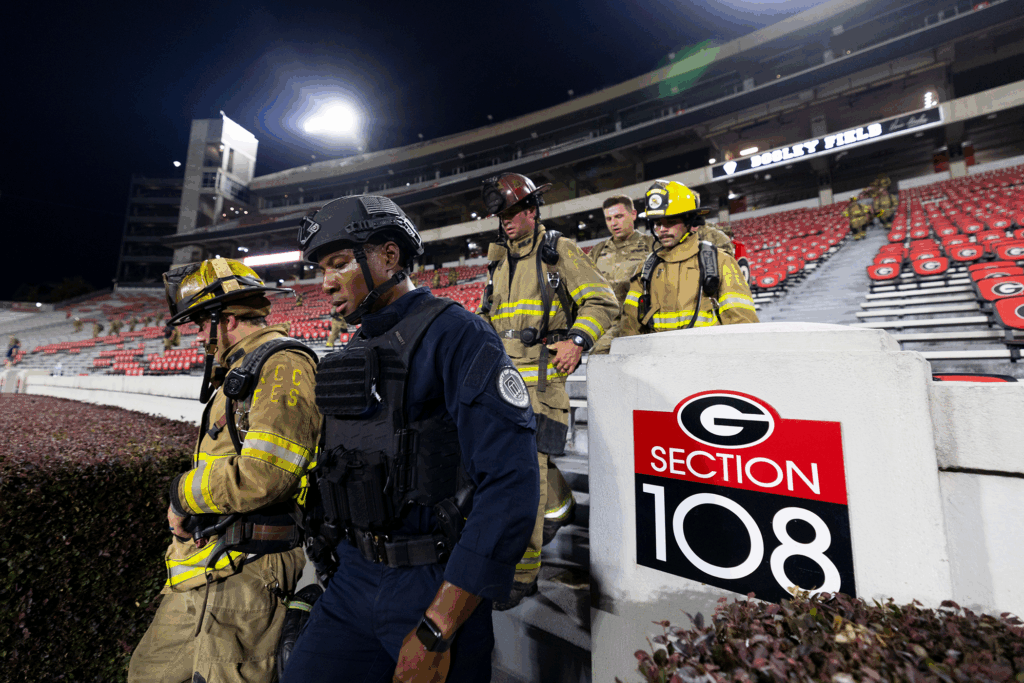 Athens-Clarke County firefighters and UGA police officer descend the steps.