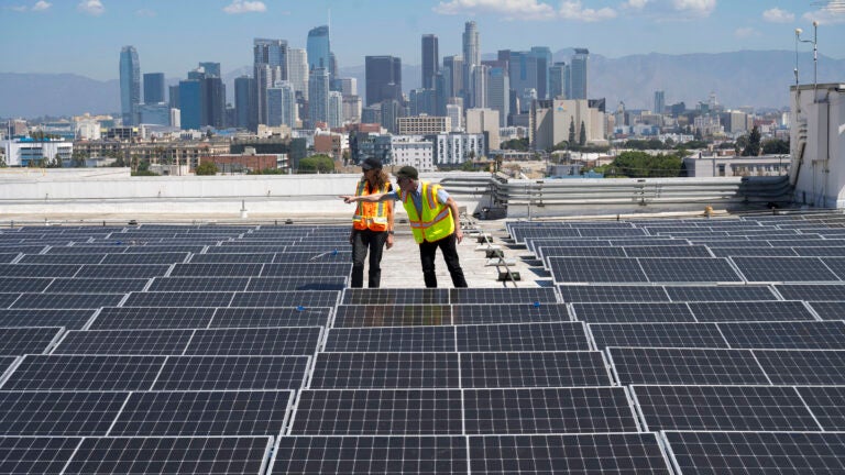 Zelinda Welch and Campbell Odening examine solar panels on CAL roof