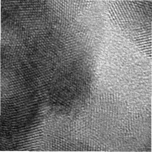 A gray-scale image of a microscope showing gold metal that appears as a wavy layer of beads.