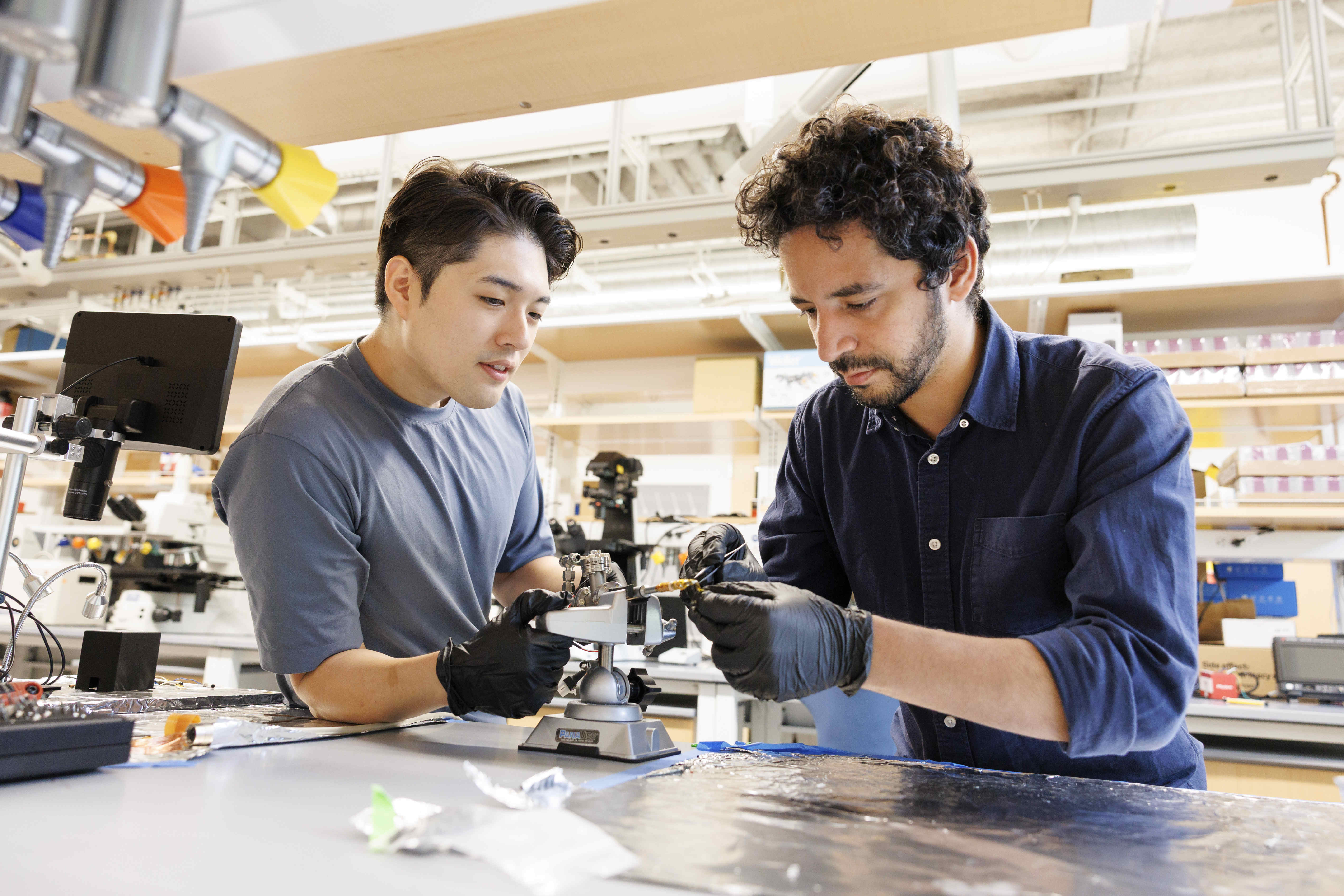 Suk Hyun Sung (left) and Ismail El Baggari collaborating on an electron microscope specimen holder.