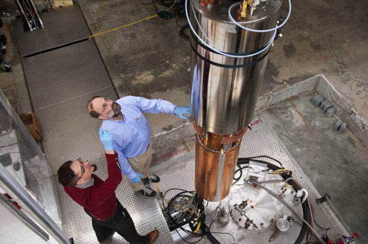 Leslie Rosenberg and Gray Rybka lower a substantial dark matter scanning apparatus into the soil