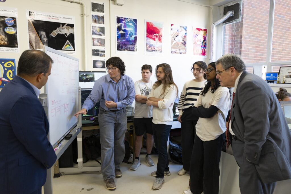 UGA student Ahmed Guler presents his team’s project on a rolling whiteboard to President Jere W. Morehead and SSRL director Deepak Mishra during a tour of the lab space.