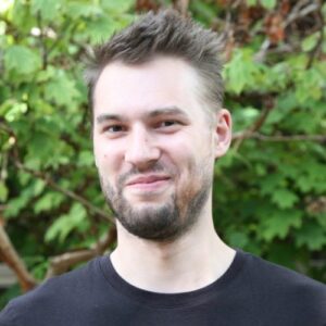Environmental portrait of a man in front of greenery outside
